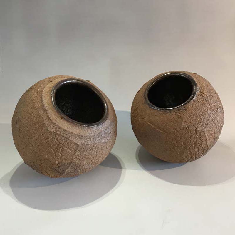 Patricia Shone From left: 27b. and 27a. Earth Jars, Hand formed crank clay, wood-fired with tenmoku glaze interior hts18 cm.